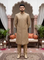 Royal golden hand-embroidered men's wedding sherwani with intricate floral and geometric patterns, elegant mandarin collar, and matching golden trousers.