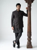 Men's premium black Jacquard prince coat with elegant textured detailing, paired with a luxury black silk shalwar kameez suit, perfect for weddings and formal occasions.
