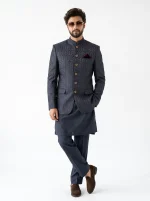 Men’s luxury charcoal grey Jacquard prince coat with intricate textured patterns, golden buttons, and maroon pocket square, paired with a premium silk shalwar kameez for weddings and formal occasions.