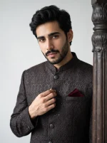 Men's premium black Jacquard prince coat with elegant textured detailing, paired with a luxury black silk shalwar kameez suit, perfect for weddings and formal occasions.