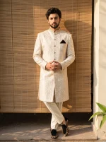 Royal ivory jacquard hand embroidered sherwani for men with mandarin collar, intricate woven patterns, matching trousers and traditional wedding shoes.