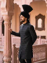 Royal black Jacquard hand-embroidered groom sherwani with textured detailing, mandarin collar, and traditional black turban.