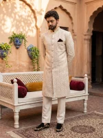Royal ivory jacquard hand embroidered sherwani for men with mandarin collar, intricate woven patterns, matching trousers and traditional wedding shoes.