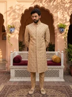 Men's champagne gold Jacquard sherwani with intricate hand embroidery, floral patterns, mandarin collar, and elegant asymmetrical front design.