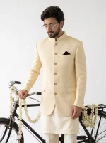 Men's Royal Ivory Jacquard Prince Coat with premium silk kurta pajama, featuring a textured pattern, mandarin collar, decorative buttons, and maroon pocket square, perfect for weddings and formal occasions.